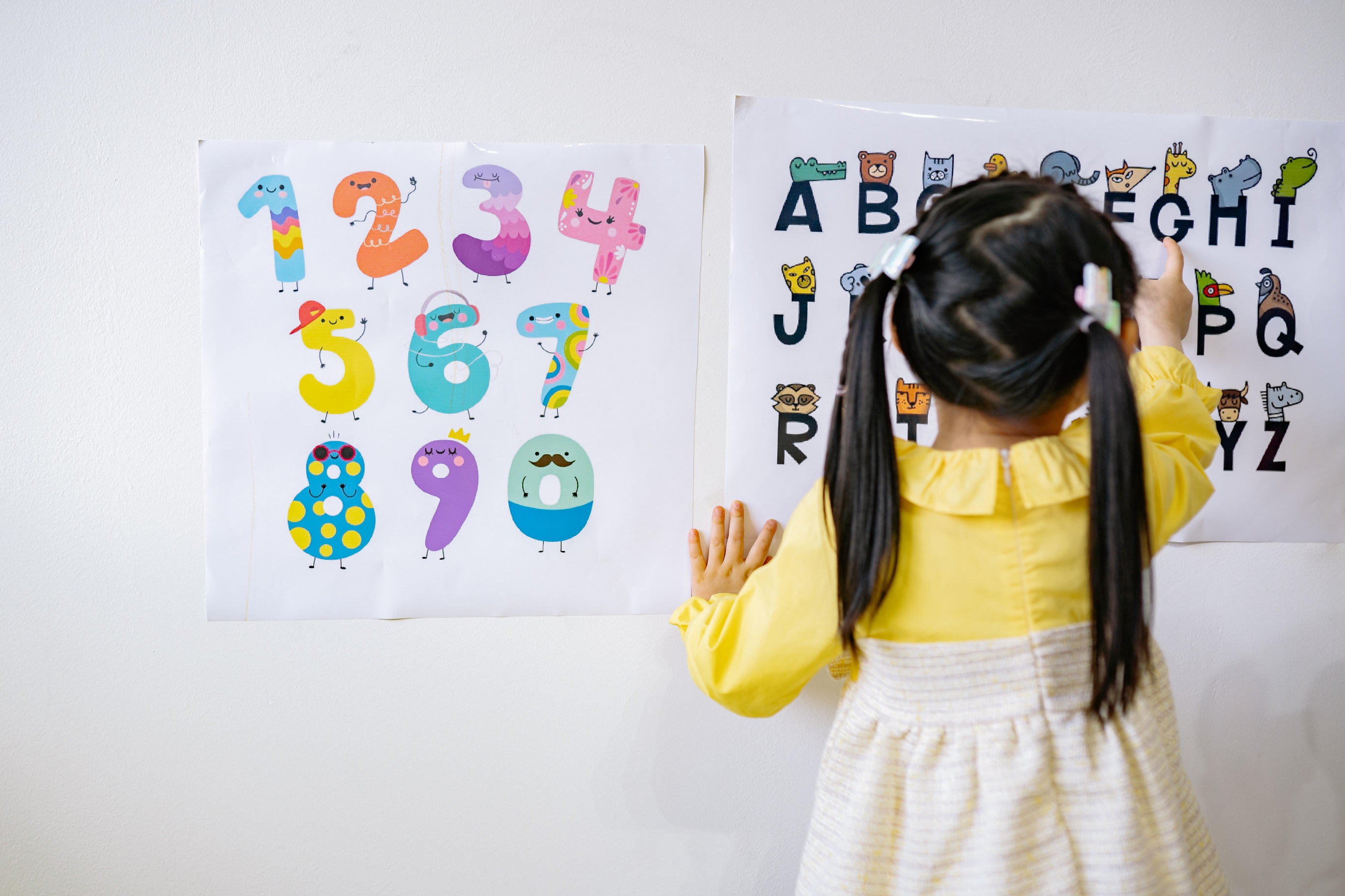 Back view of girl learning ABC and numbers on light board jpg